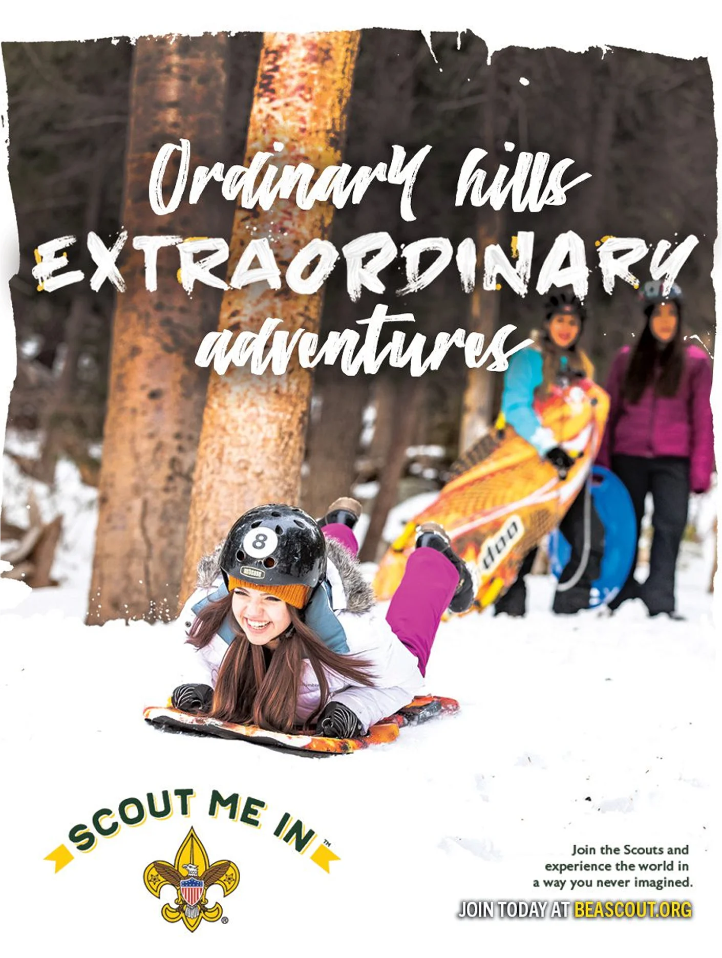 Children sledding down a snowy hill on a sunny day.